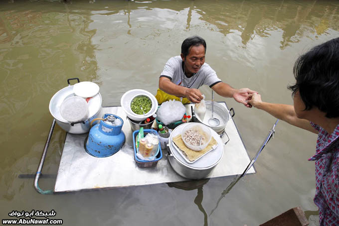 صور حول العالم : خلع أسنان أسد + تايلندي يبيع الطعام في الفيضان .. والمزيد